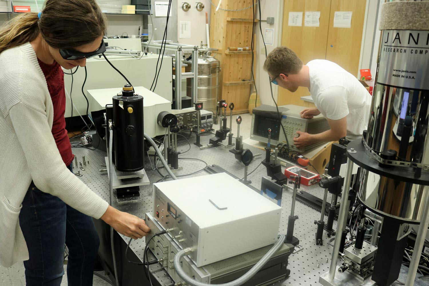 Ph.D. candidates Erica Calman and Lewis Fowler-Gerace adjust the electronics and optics used for the experiment