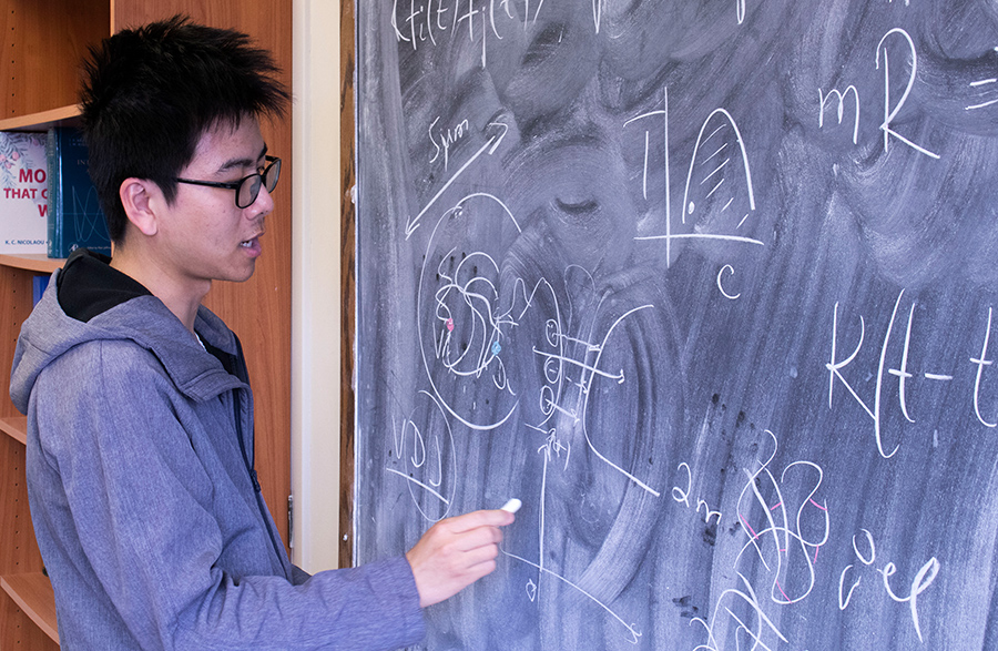 Physics graduate student Bin Wang, who works with Dudko, charts temporal and spatial aspects of the research. Photo by Michelle Fredricks, UC San Diego Physical Sciences