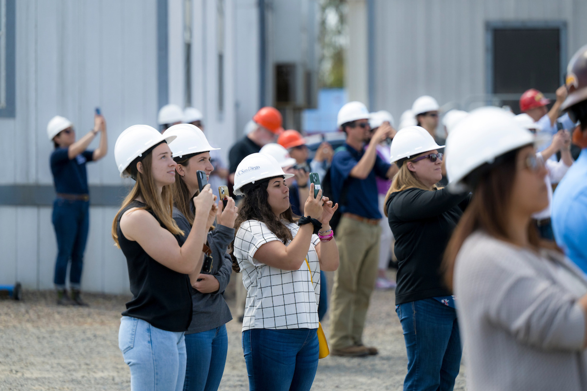 Researchers and project-affiliated viewers watch the project tests with phones in hand.