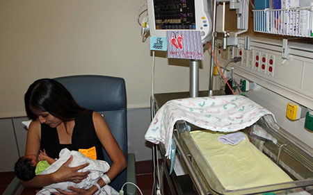Image: Melissa Renteria holds her newborn baby, Arthur, while he’s monitored by the HeRO technology