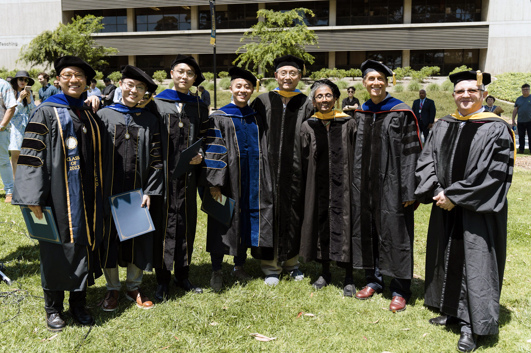 Students and faculty in their graduation robes pose for a photo.