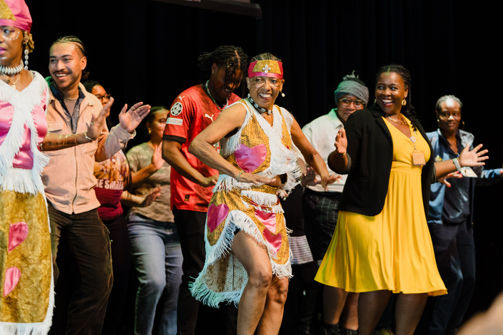 Teye Sa Thiosanne African Drum & Dance Company on stage with event attendees.