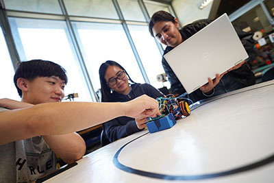 Students with a small line-following car they built