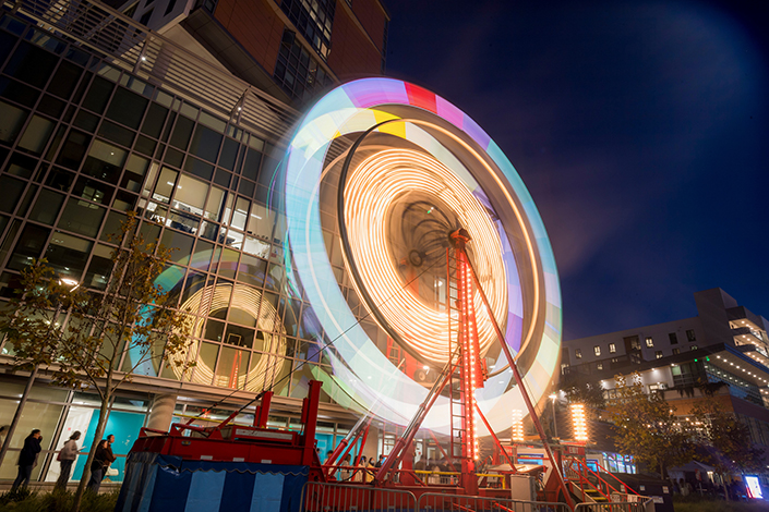 Time lapse image of a ferris wheel with colorful lights blurred.