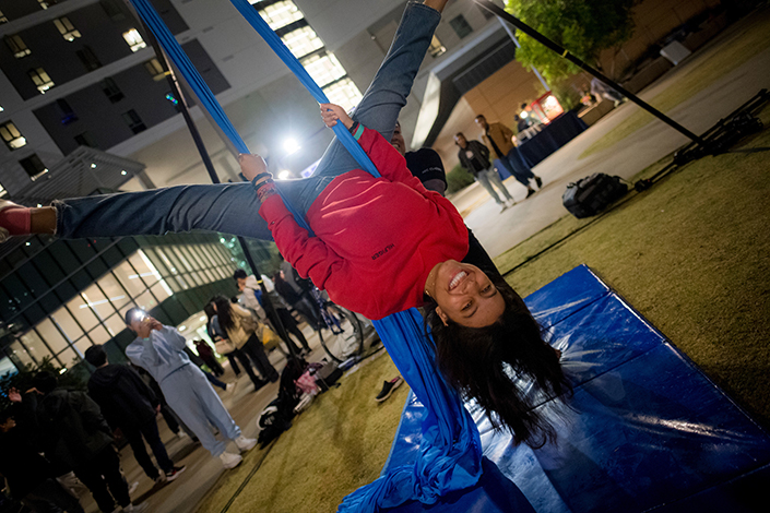 A woman hangs upside down using an aerial silk.