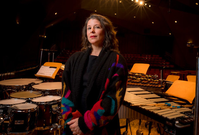 Amy Cimini on stage surrounded by musical instruments.