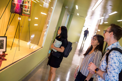 Attendees look at the display cases in Price Center.