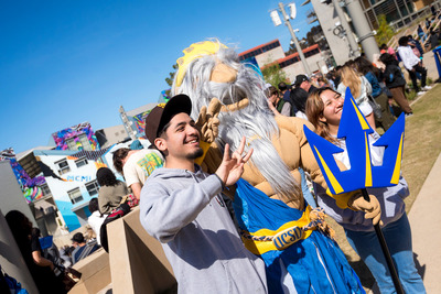 Students take a picture with King Triton on Triton Day.