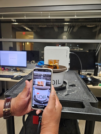 A phone is pointed at an RFID tag on a flower pot