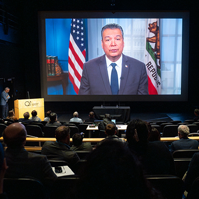 Alex Padilla on large screen speaking to audience