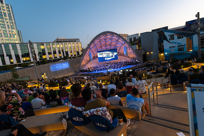 Audiences watching a show at the Epstein Family Amphitheater at dusk