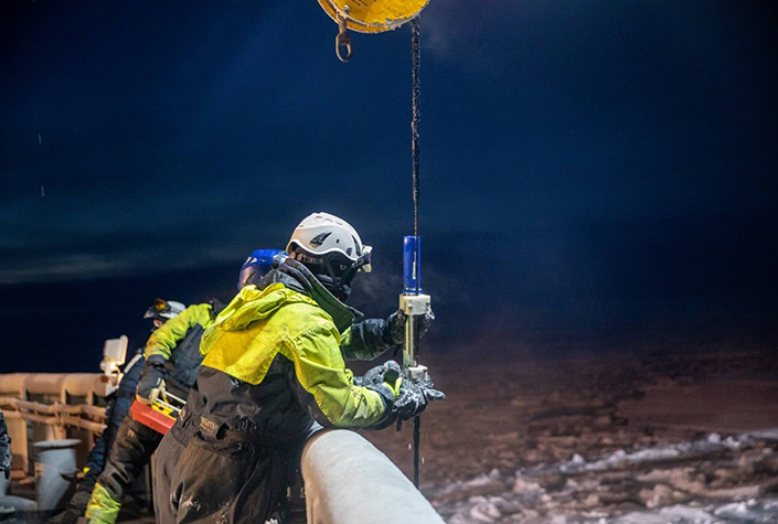 A researcher measuring acoustic signals in the Arctic Ocean. 