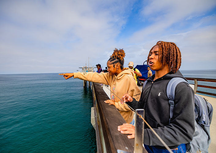Students overlooking the ocean on Scripps Pier.
