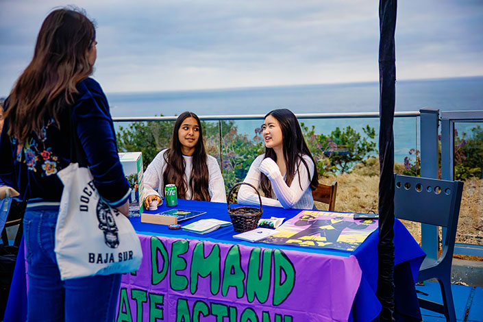Two students host a climate outreach table at an event
