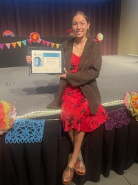 Briana Gomez holding her scholarship certificate.