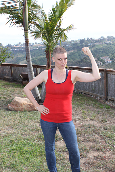 Brubaker with shaved head standing flexing left bicep
