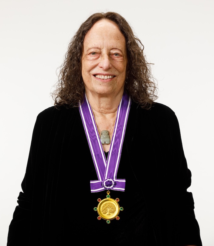 Woman with curly brown hair wearing Kyoto Prize medal