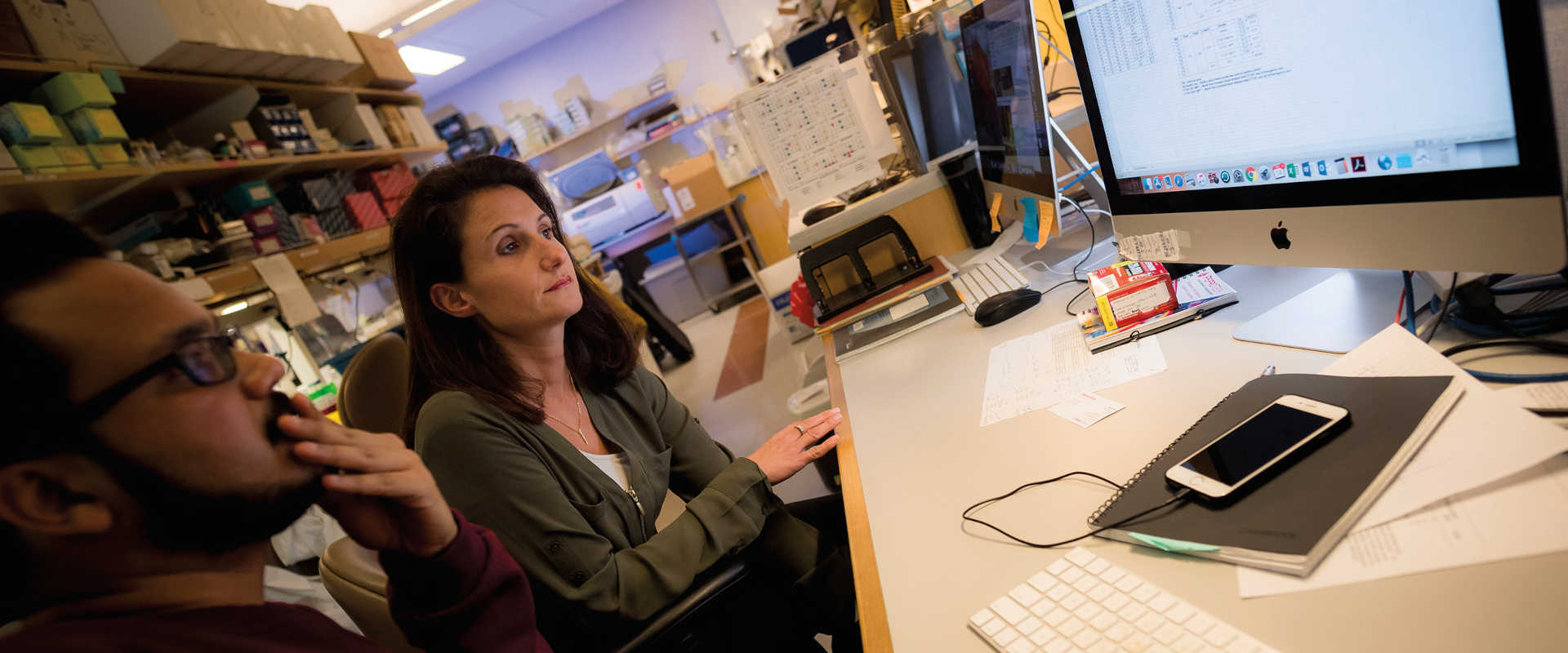 Stephanie Cherqui and a colleague look at data on a computer screen.