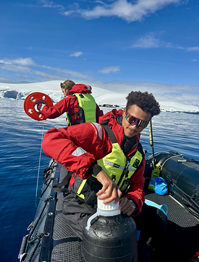 Christian Johnson collecting samples with chief scientist Meghan Goggins.