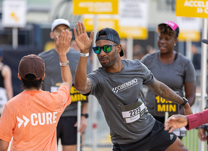 Man in sunglasses giving high five to woman with shirt that reads