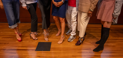 Audience members posing with Weitzman wearing his own designs. 