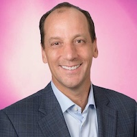 Photo of man smiling with suit against pink background