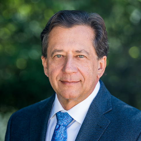 Headshot of Drew Senyei with greenery in background