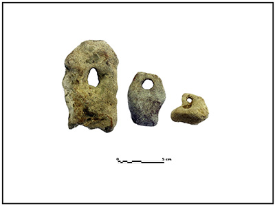 Stone fishing net weights with a single hole through each stone.