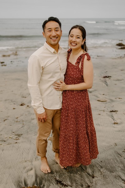 A couple smile for a photo on the beach
