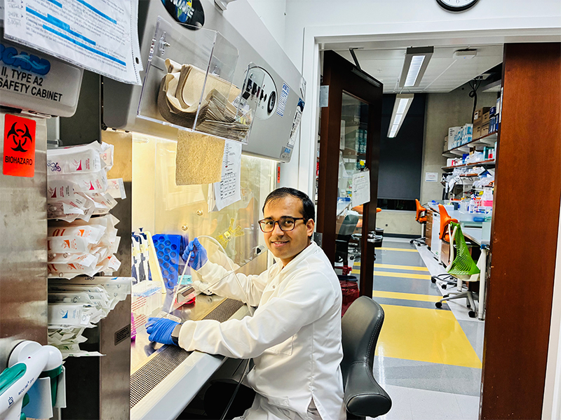 Male researcher conducting experiment in a white lab coat.