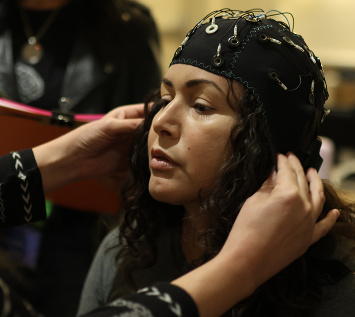 Photo of a woman with a cap that measures brain activity on