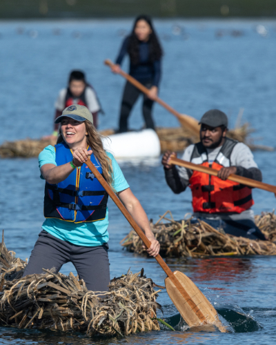 Group of community volunteers paddle in traditional handcrafted Kumeyaay tule boats.