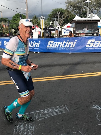 Man running in a Ironman while smiling for the camera
