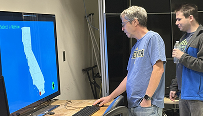 Student and guest looking at large screen