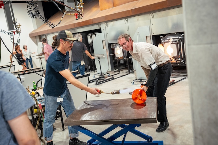 Two men working in glass studio