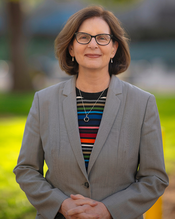Outdoor portrait of Carol Padden in striped shirt and gray blazer
