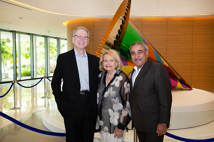 Irwin and Joan Jacobs with Chancellor Khosla in front of Jeff Koons' Party Hat (Orange) 