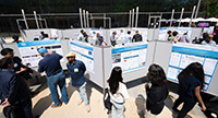 Students stand in front of their research posters in the Atkinson Hall courtyard