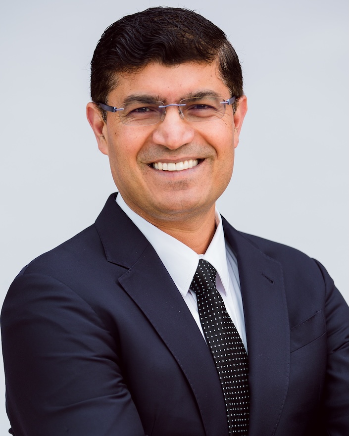 Headshot of man in suit with glasses