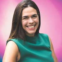 Woman smiling with green top and pink background