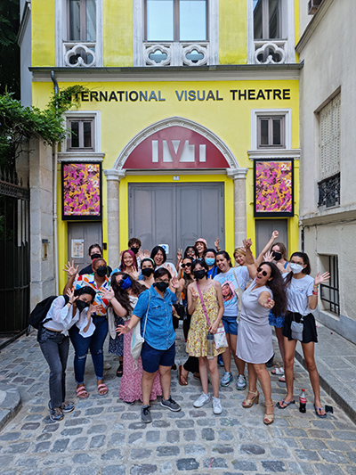 Group in front of yellow facade of the International Visual Theatre