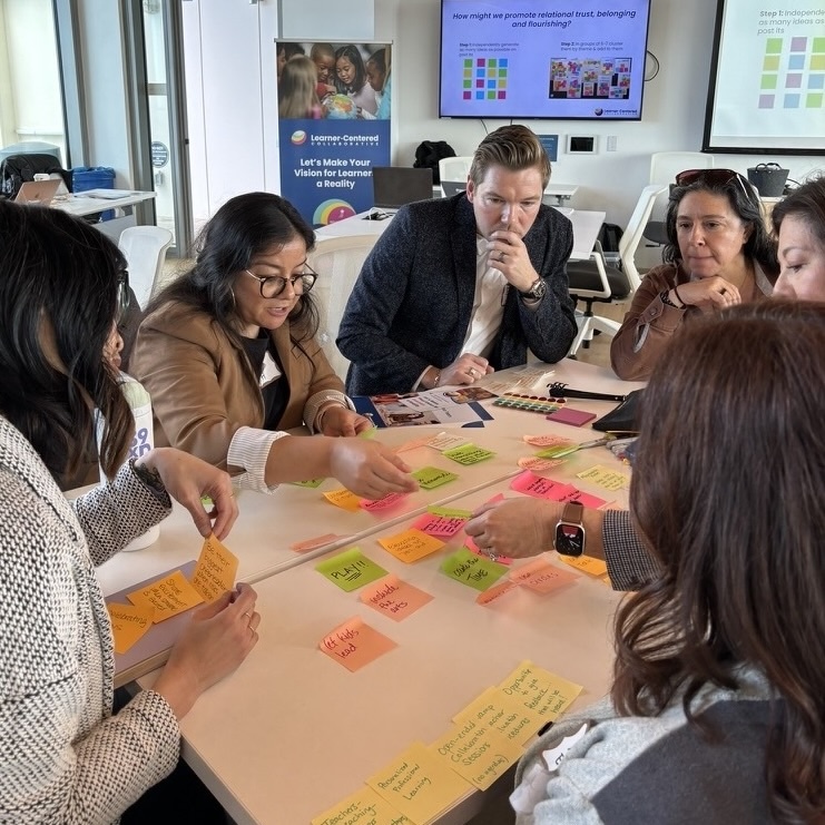 People gathered at a table with sticky notes