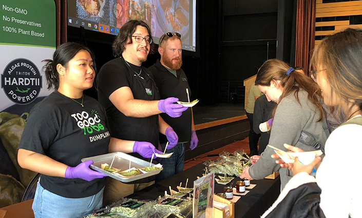 Many attendees at the Sustainable Food Expo were intrigued by a brand-new algae-based dumpling, which were being sampled from the table of Triton Algae Innovations, under their consumer-facing brand “Too Good To Be Foods.”