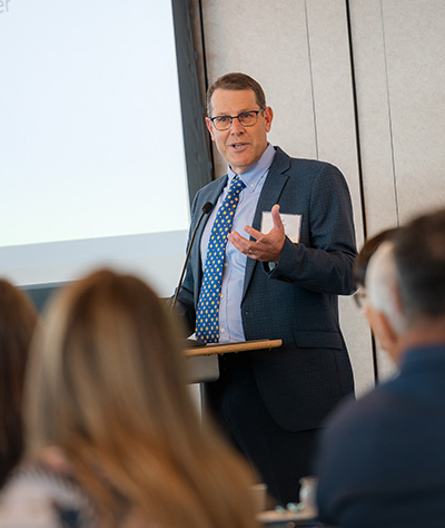 Chief Procurement Officer Ted Johnson speaking on stage in front of a podium at the Partnership Summit.