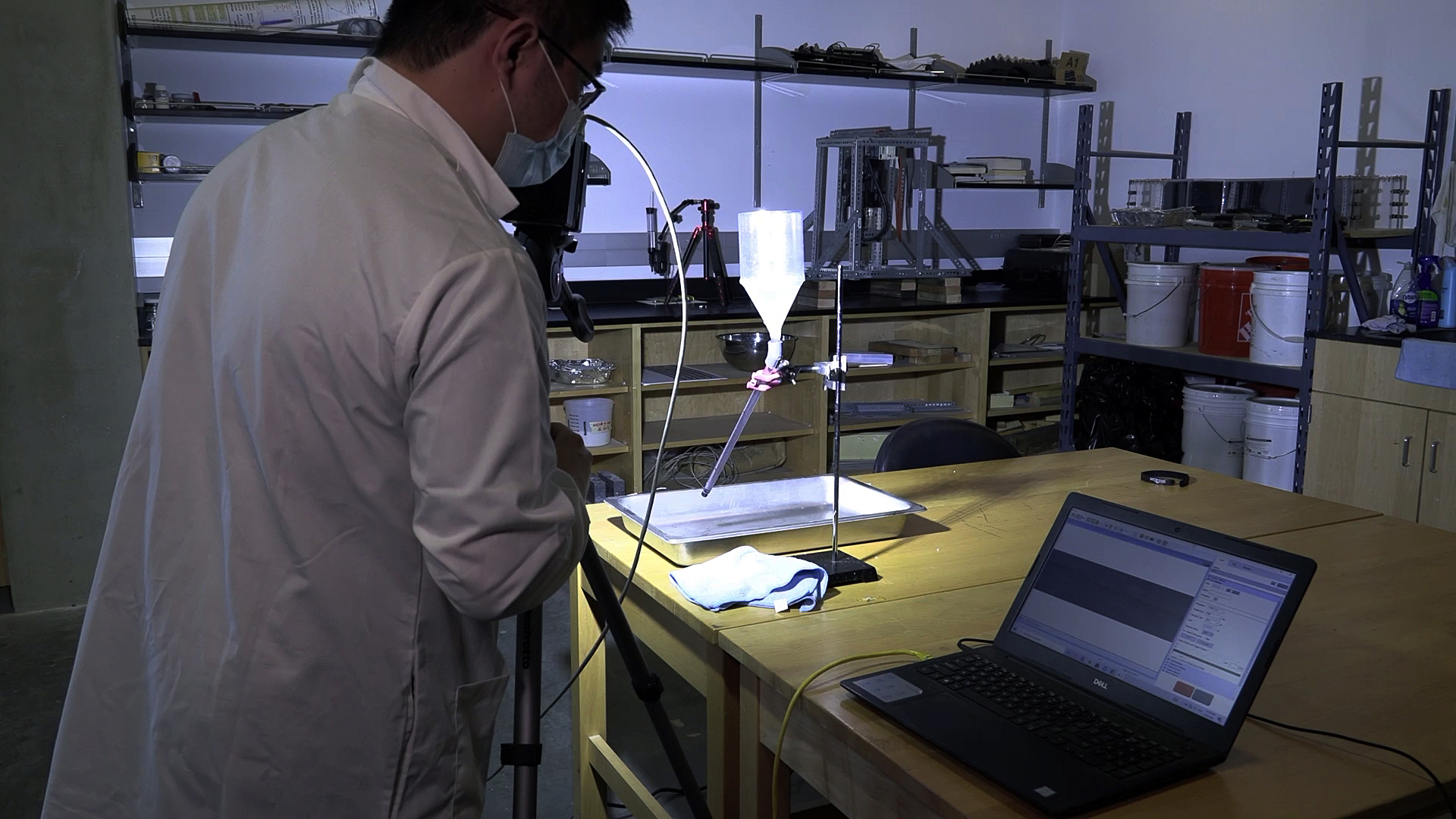 Picture of a PhD student looking at experiment results on his laptop