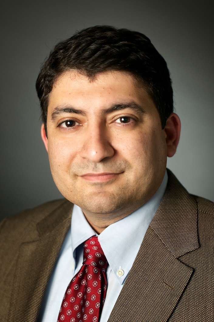 Headshot of man in suit and red tie