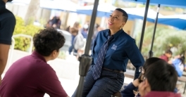 A group of people posing in front of a conference banner and smiling 