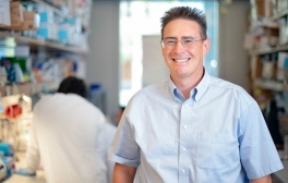 Rob Knight stands in his laboratory as other researchers work behind him.