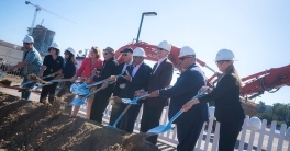 Groundbreaking attendees break ground on the Triton Center project.