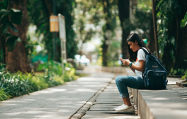 Person sitting down looking at their phone.